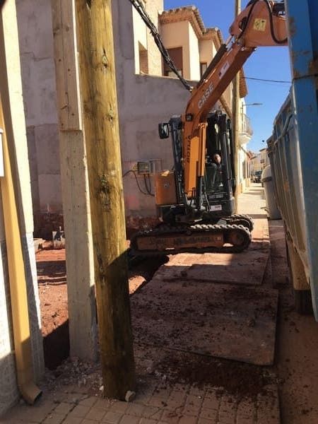 Un hombre conduce una excavadora en un sitio de construcción.