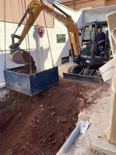 Una excavadora está cavando un hoyo en el suelo.