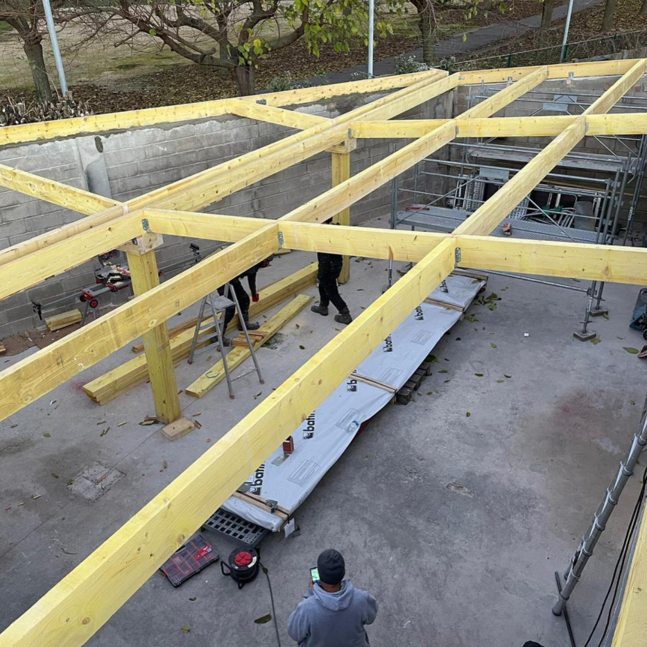 Chantier avec la mise en place d'une charpente.