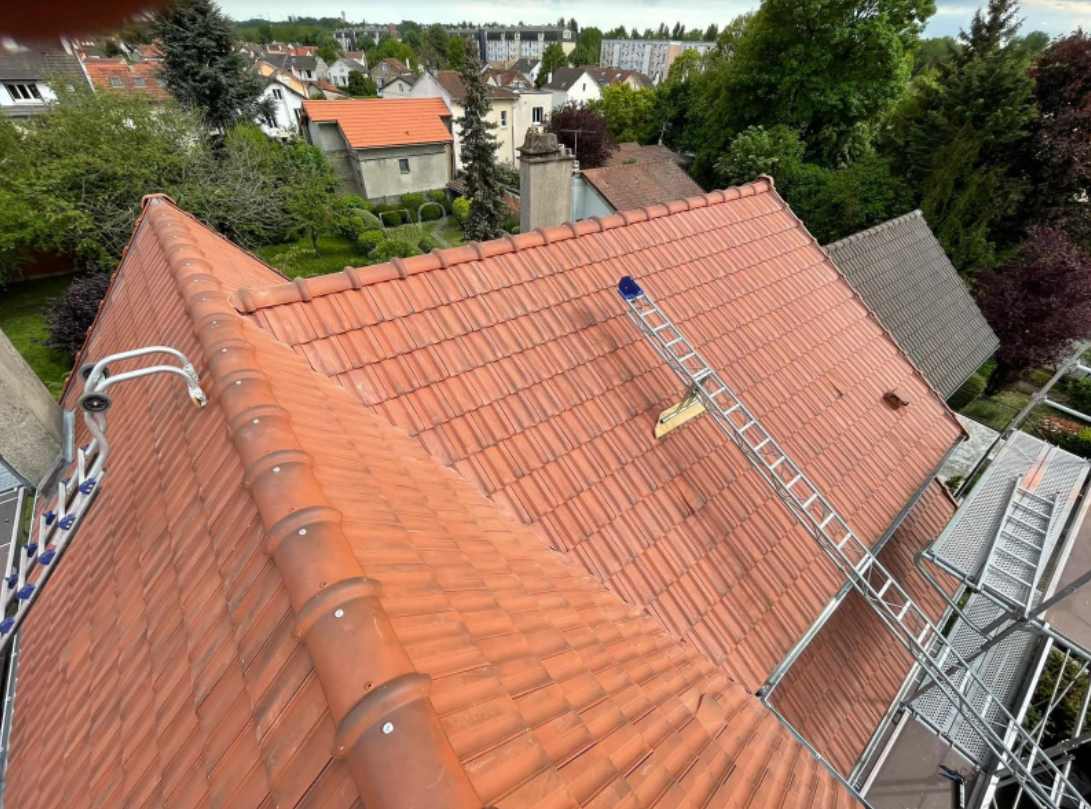 Grande toiture avec une échelle posée.