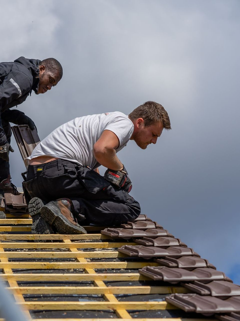 Deux couvreurs en train d'examiner une toiture.