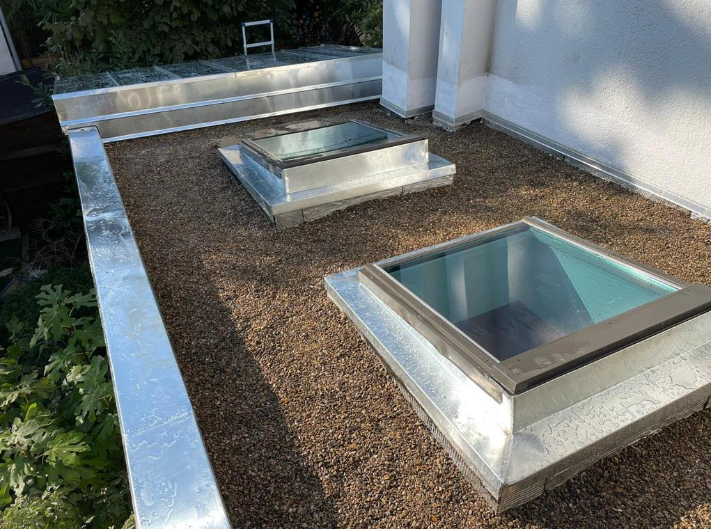 Deux fenêtres de toit sur un toit plat.