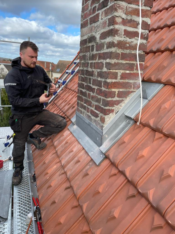 Couvreur à côté d'une cheminée.