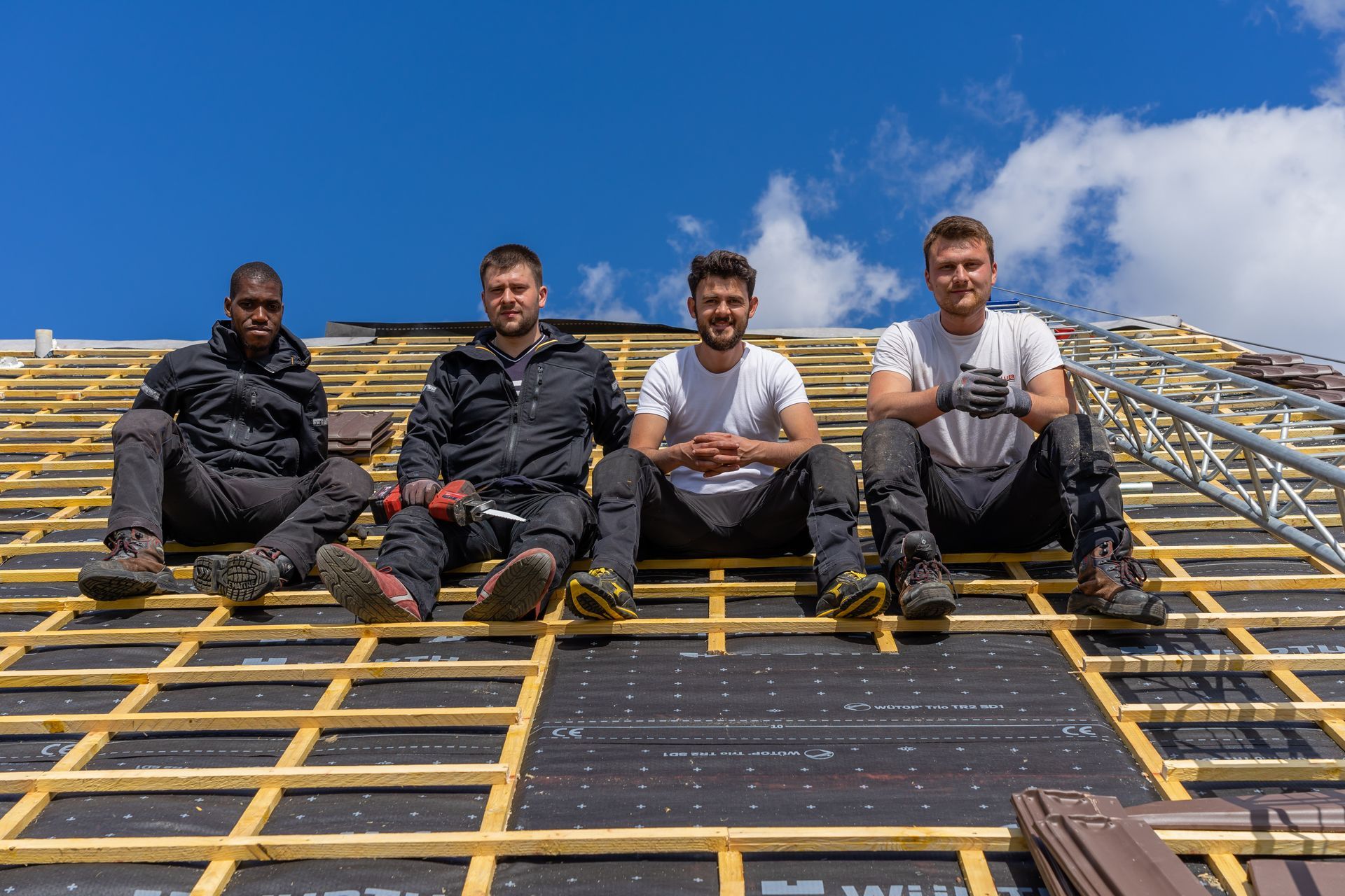 L'équipe de Chevallier Couverture assise sur une toiture.