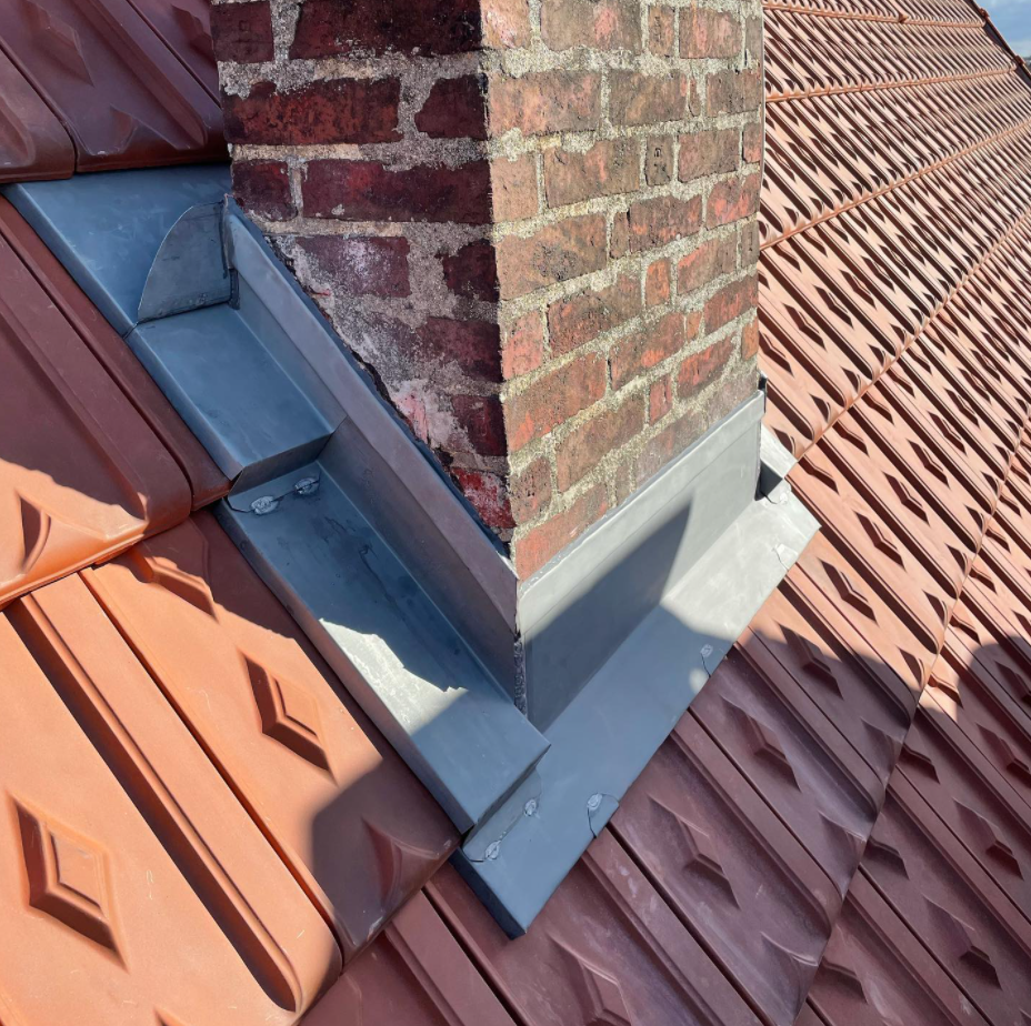 Des éléments en zinc autour d'une cheminée.