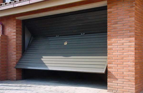 Un edificio de ladrillo con una puerta de garaje que está abierta.