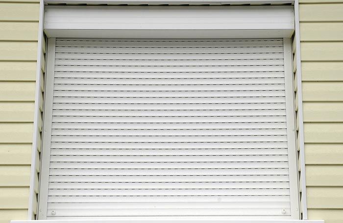 Una persiana blanca en una ventana de una casa.