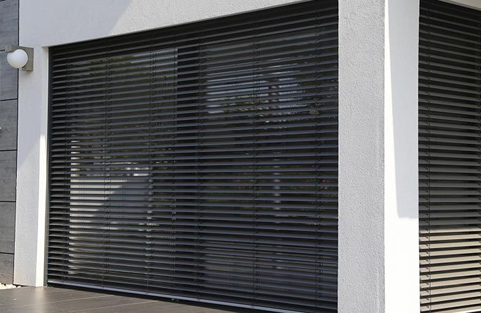 Una gran ventana con persianas negras.