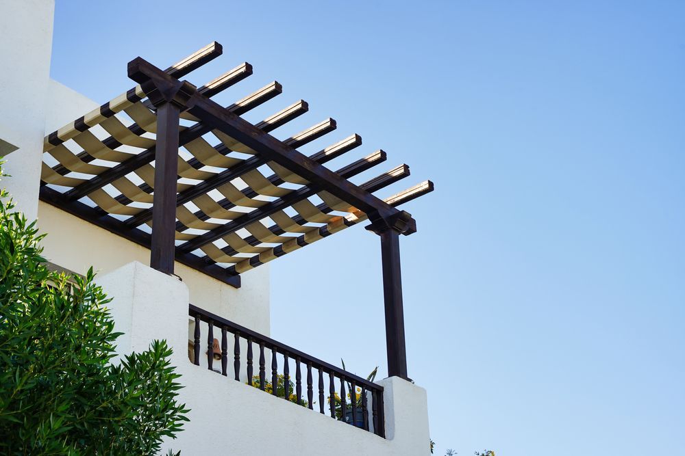 Un edificio blanco con una pérgola encima.