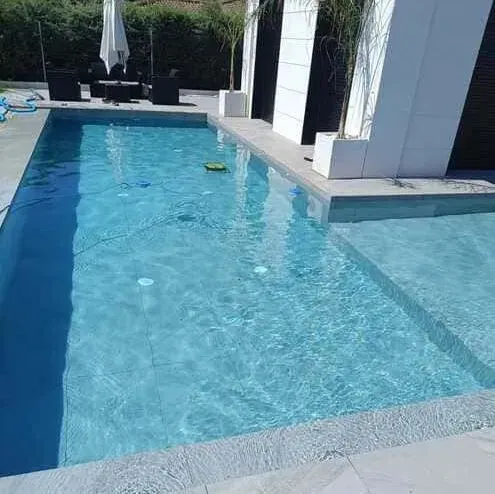 Hay una gran piscina en el patio trasero de una casa.