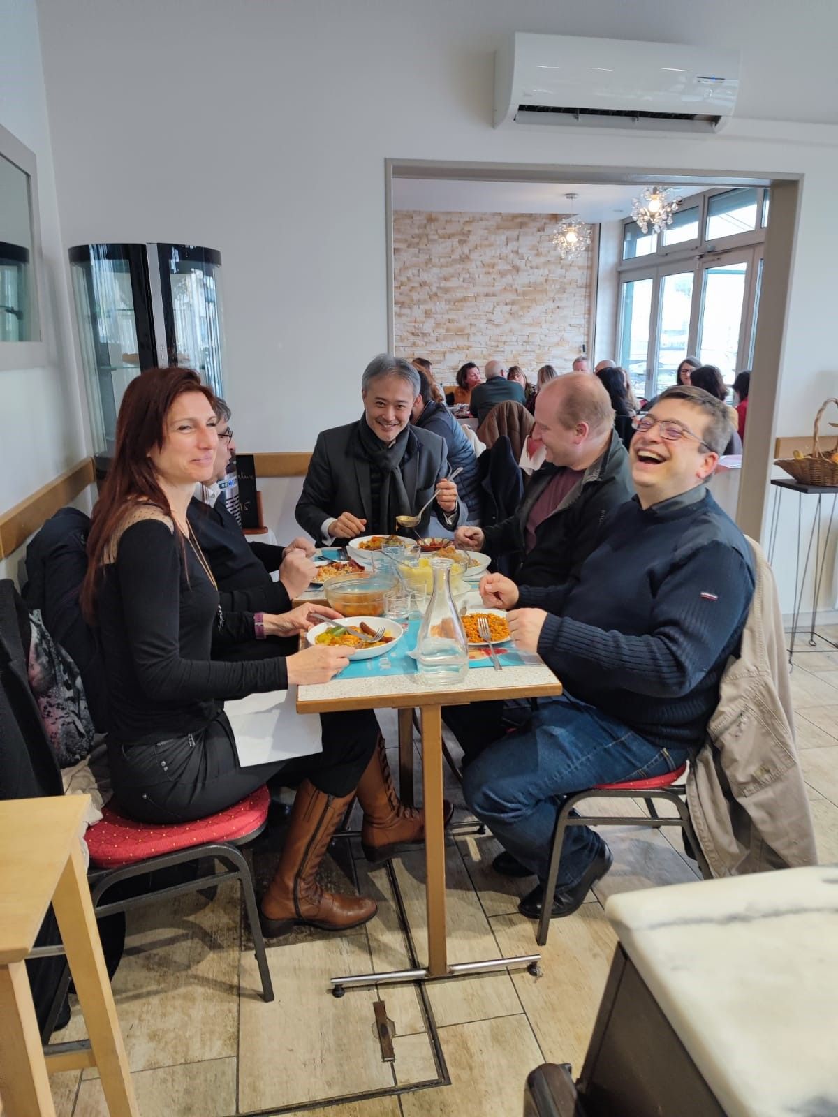 Personnes assises en train de manger autour d'une table et d'un couscous