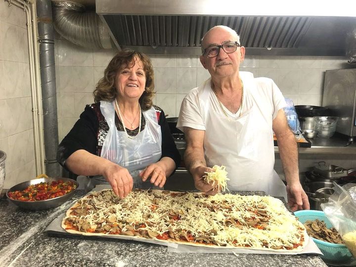 Duo de cuisiniers en train de réaliser une pizza