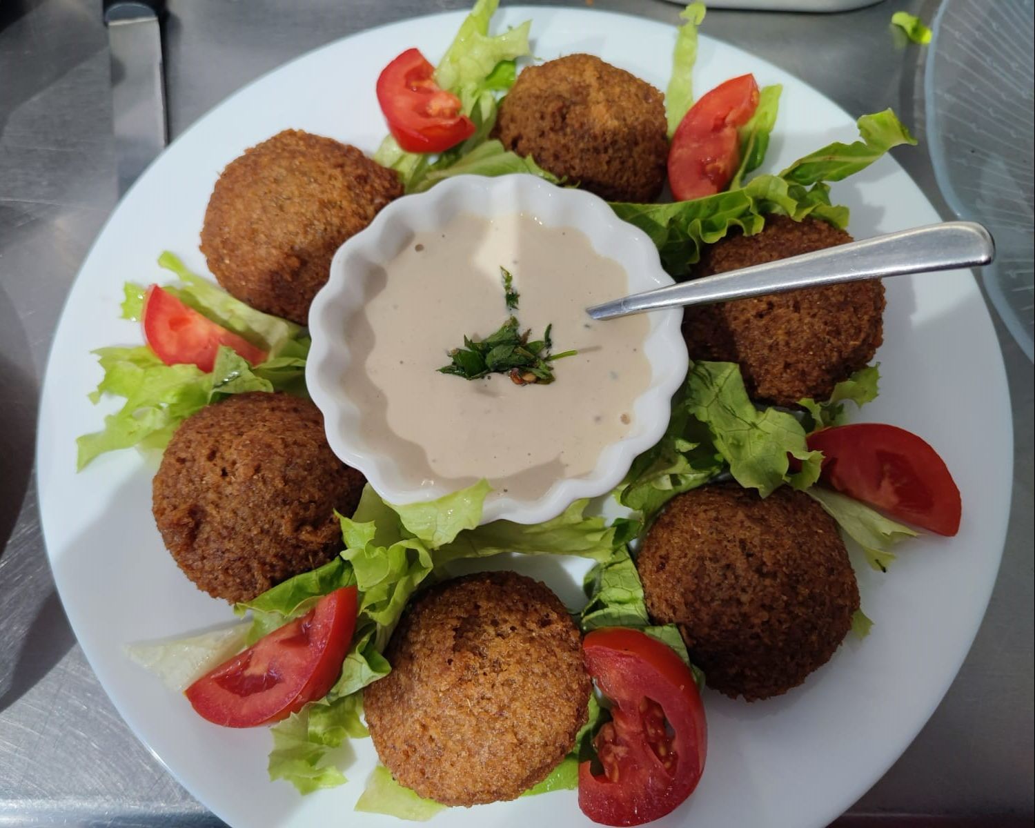 Falafels dans une assiette avec une sauce au houmous au milieu