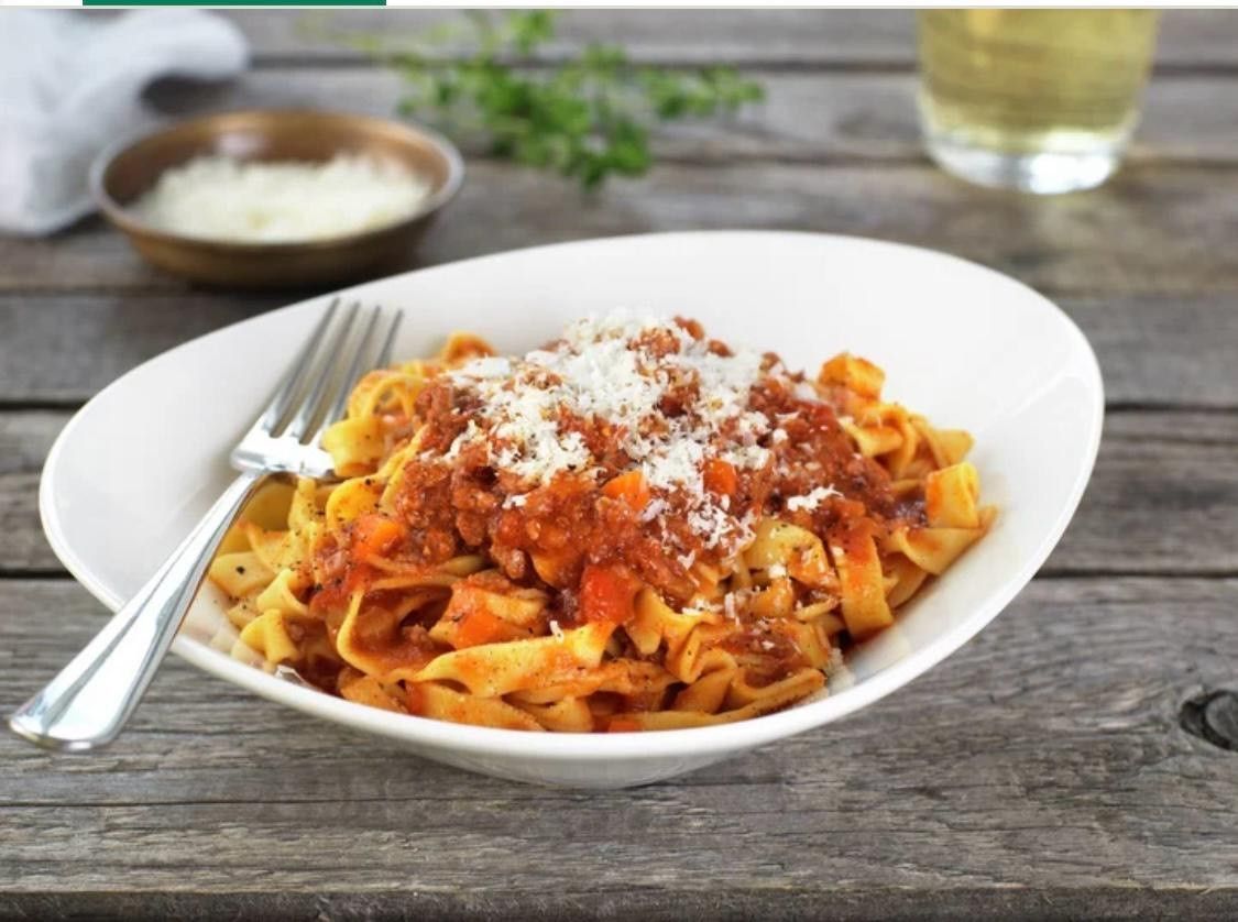 Un bol de pâtes avec sauce et fromage et une fourchette