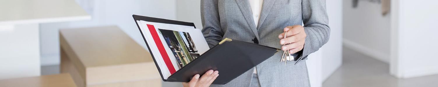 Personne tenant un portfolio noir ouvert avec un graphique coloré dans un bureau lumineux
