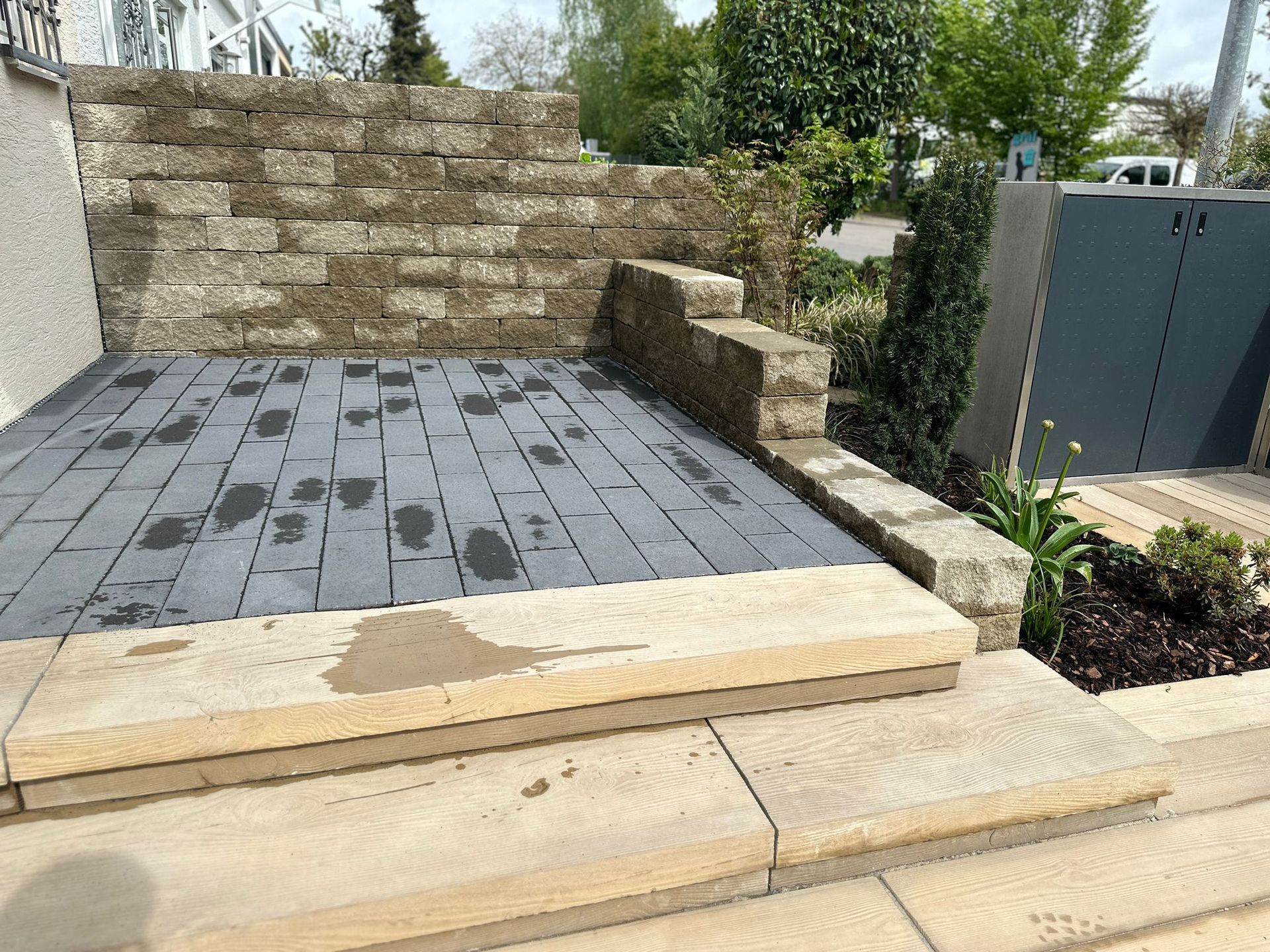 Eine Terrasse mit Stufen und einer Backsteinmauer im Hintergrund.