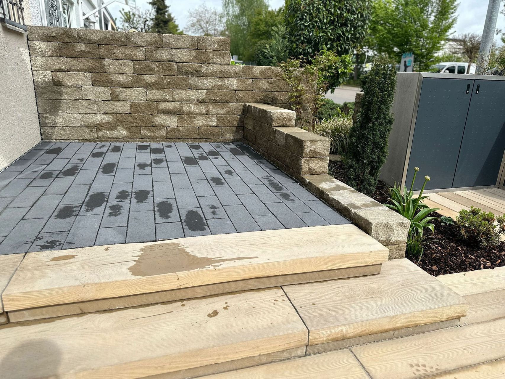 Eine Terrasse mit Stufen und einer Backsteinmauer im Hintergrund.