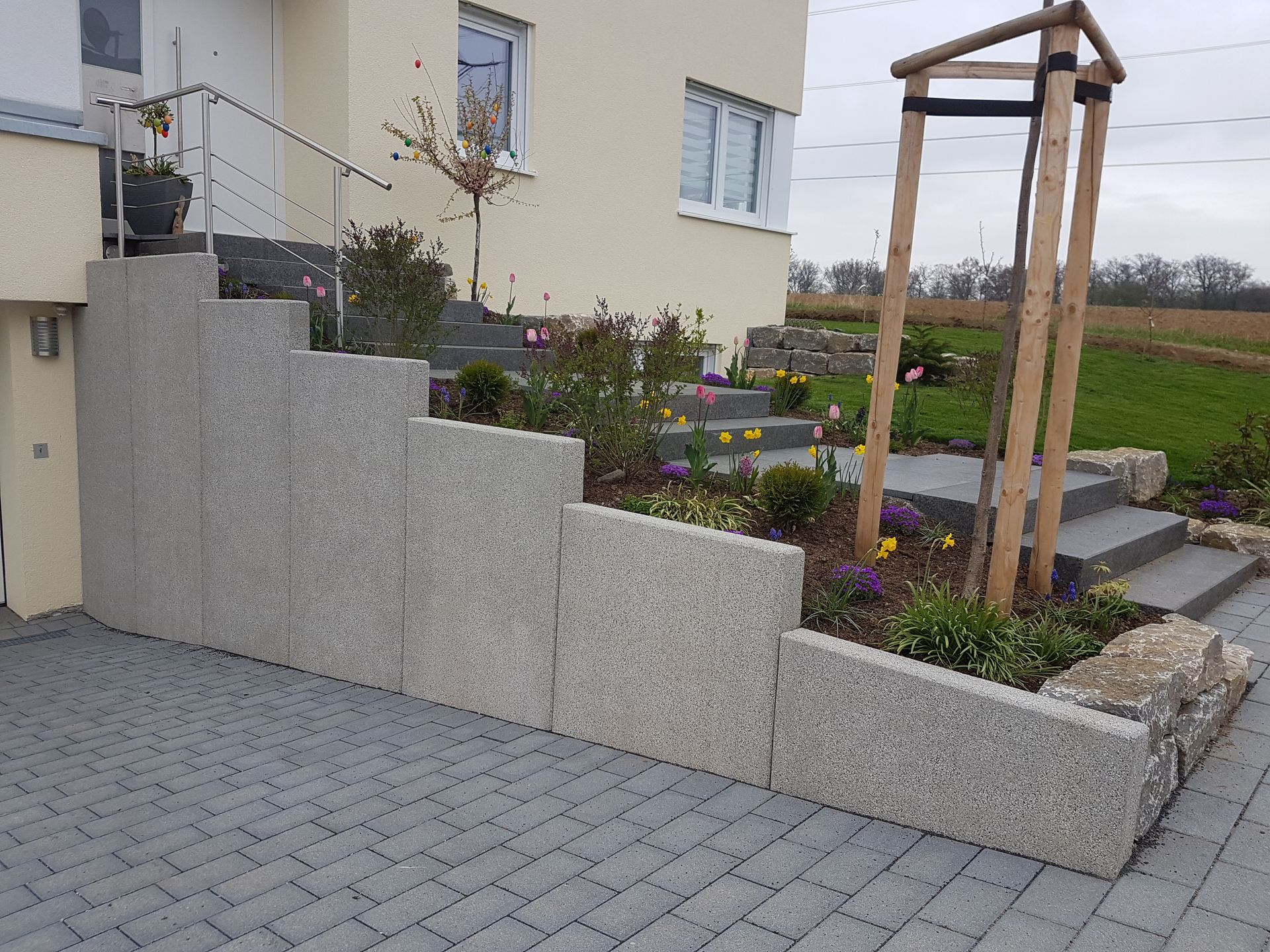 Ein Haus mit Treppe und einer Steinmauer davor