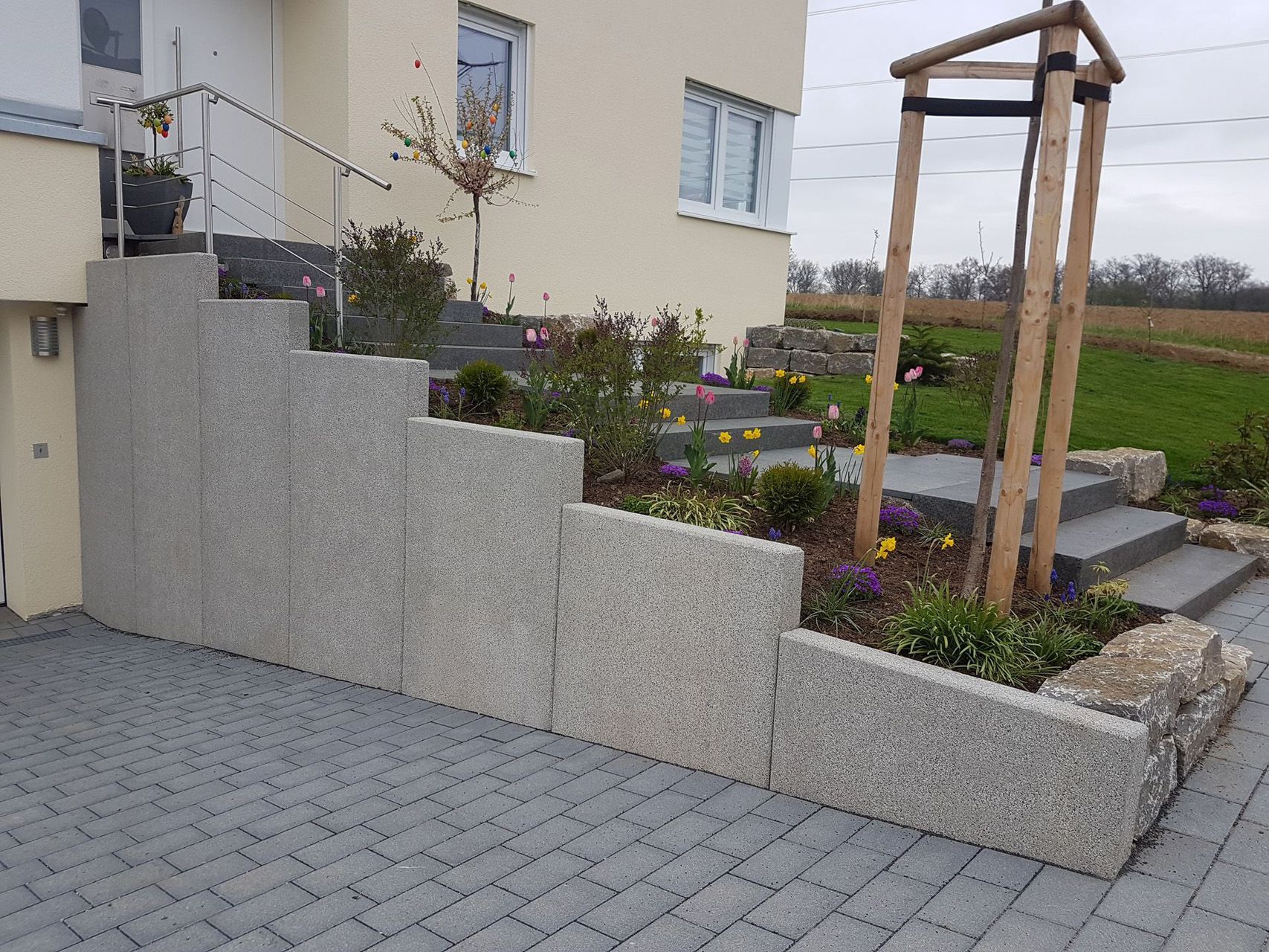 Ein Haus mit Treppe und einer Steinmauer davor