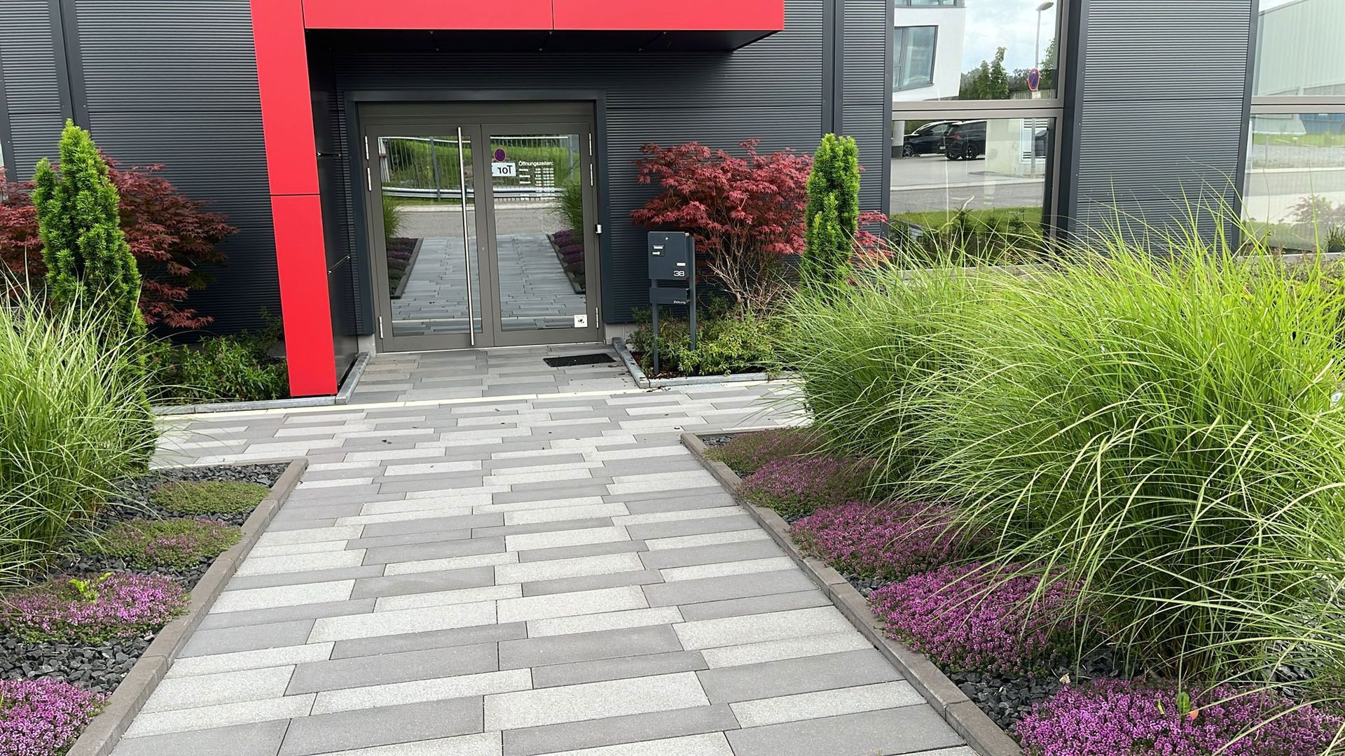 Es gibt einen Gehweg, der zum Eingang eines Gebäudes führt.