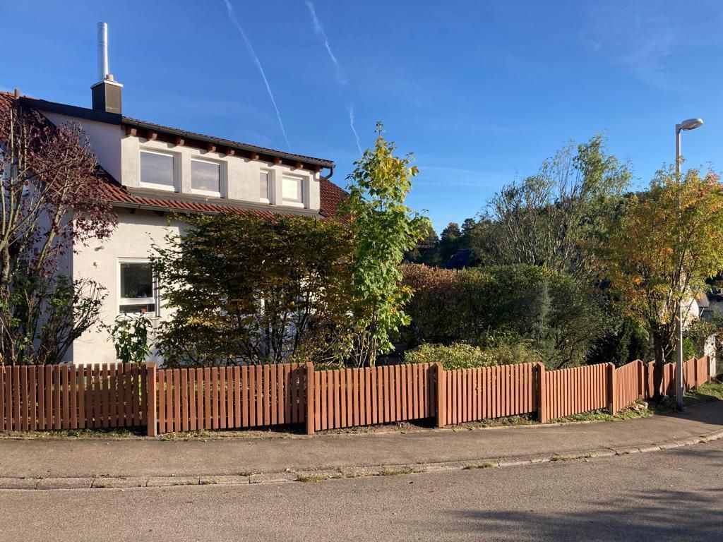 Ein Haus mit einem Holzzaun davor