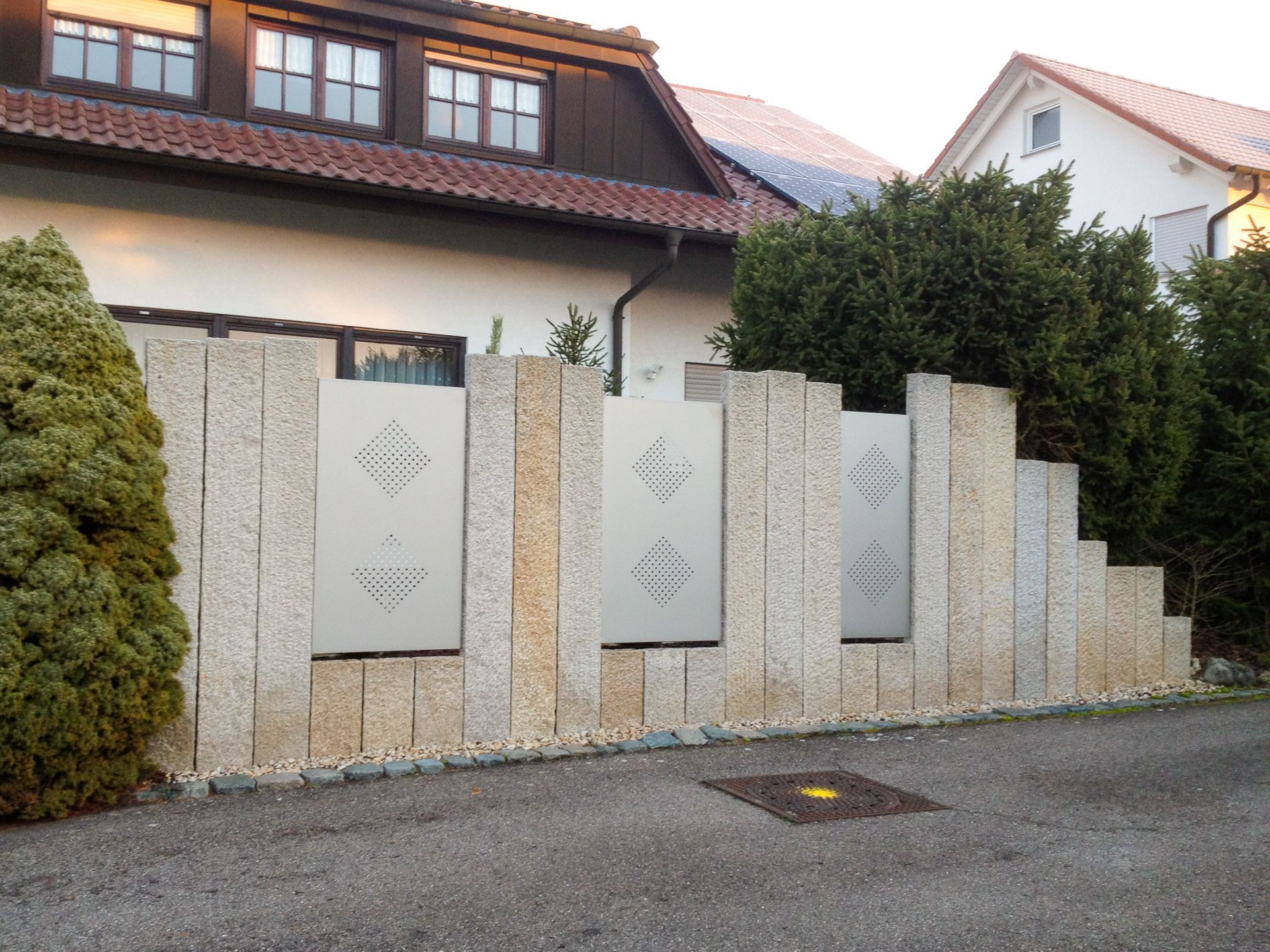 Ein Haus mit einem Steinzaun davor