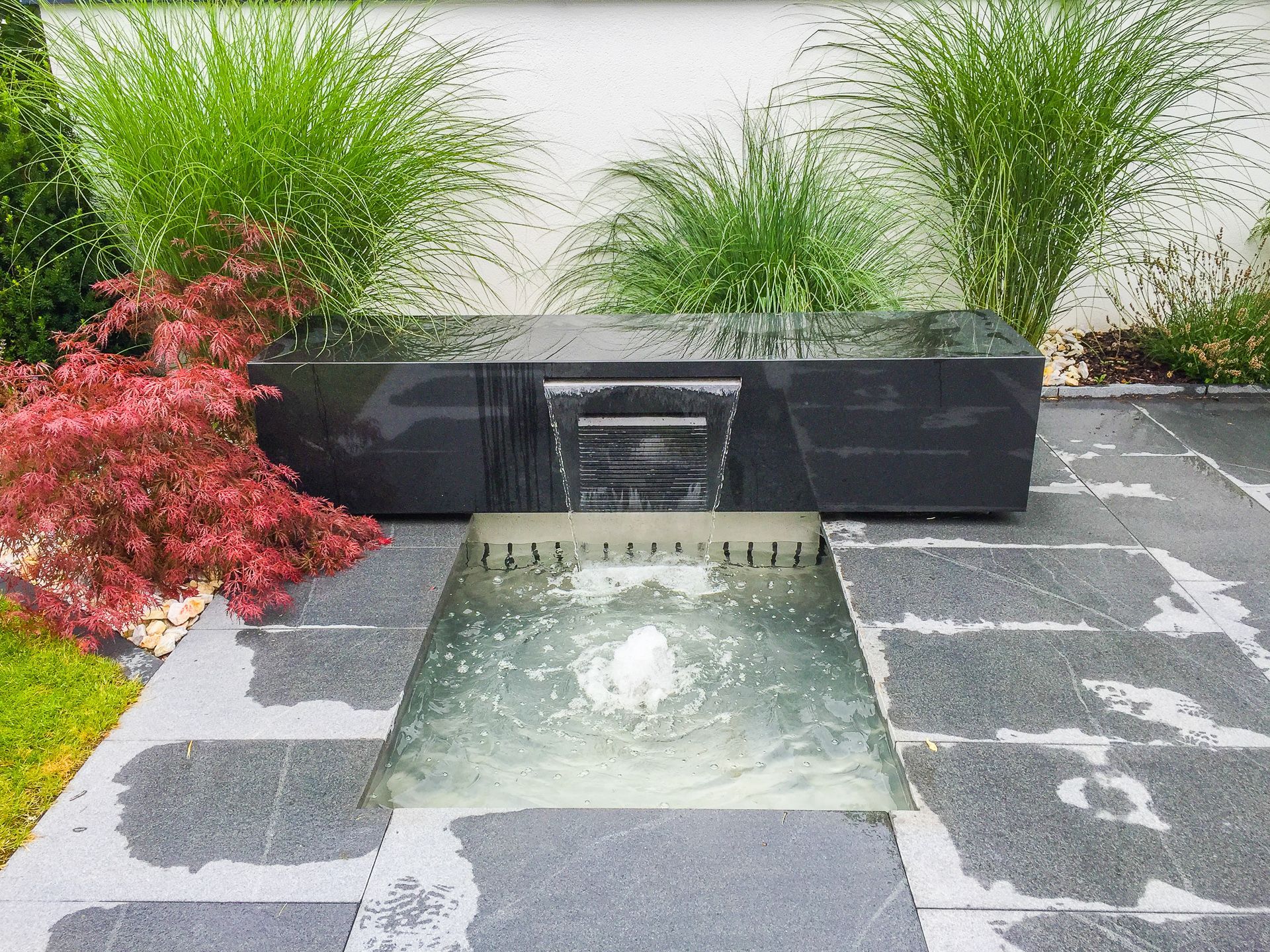 In der Mitte des Gartens befindet sich ein Springbrunnen.