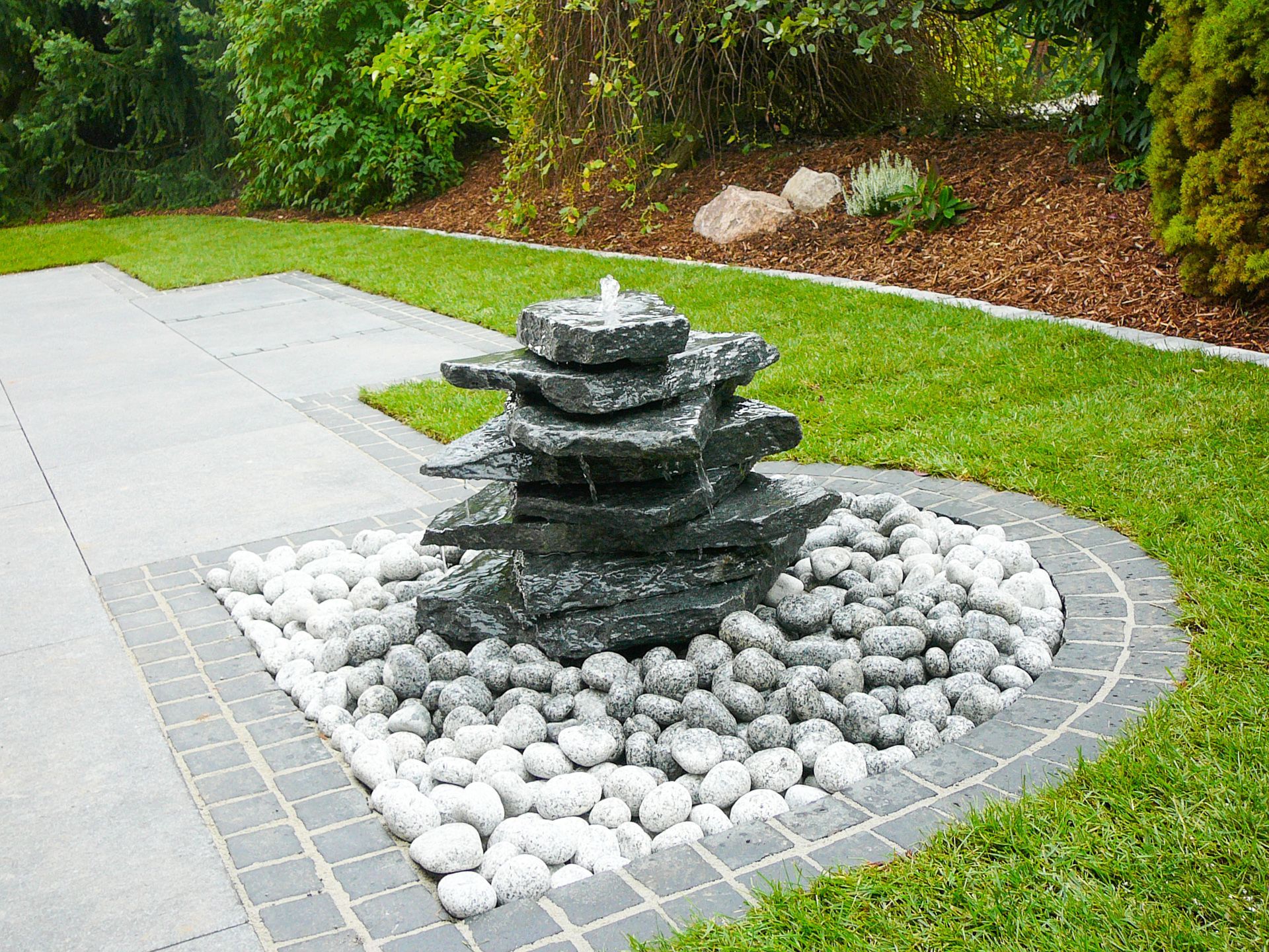 Brunnen von Steinen und Kies umgeben.