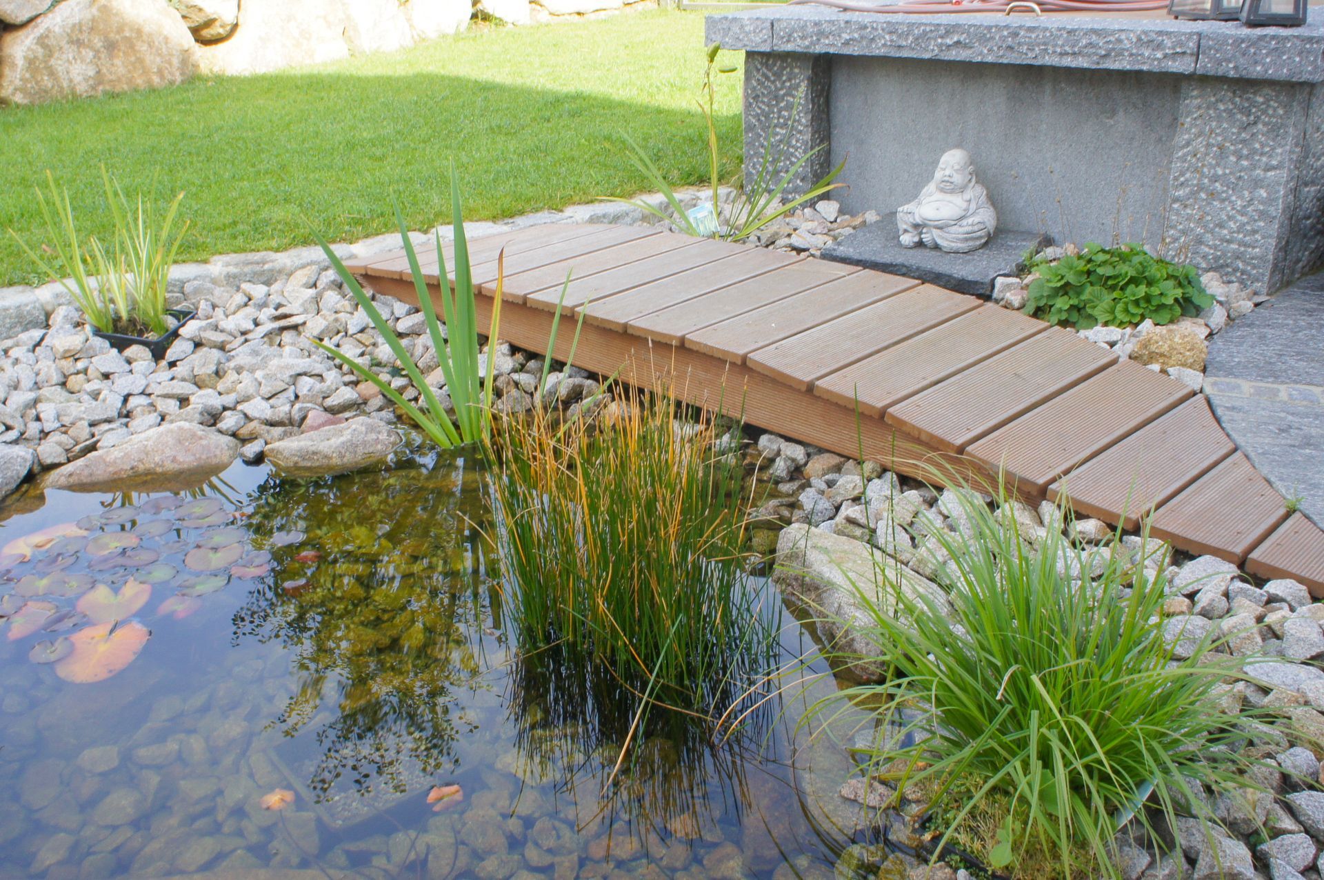 Eine Holzbrücke über einen Teich in einem Garten