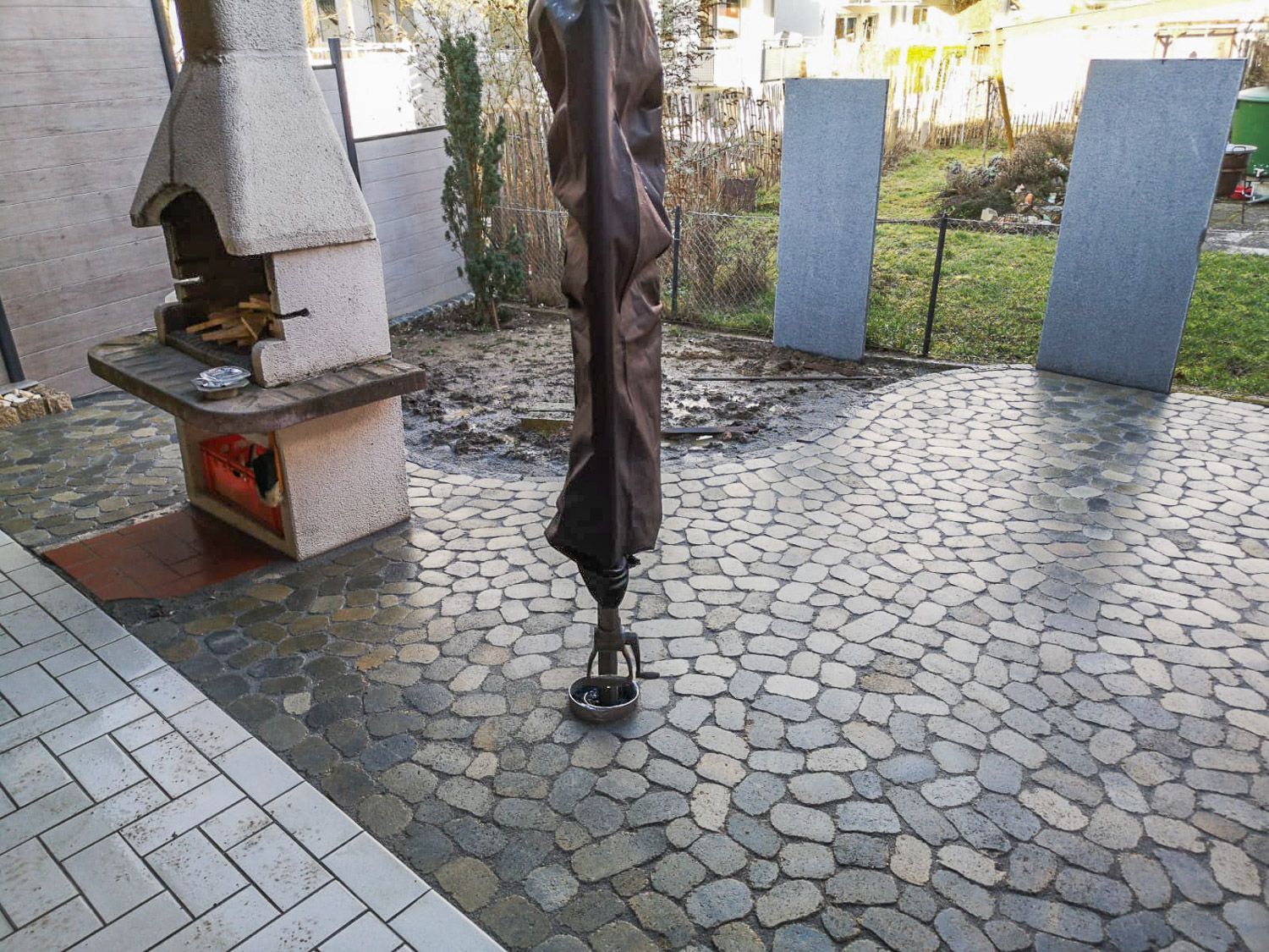 Eine Terrasse mit Kamin und Sonnenschirm