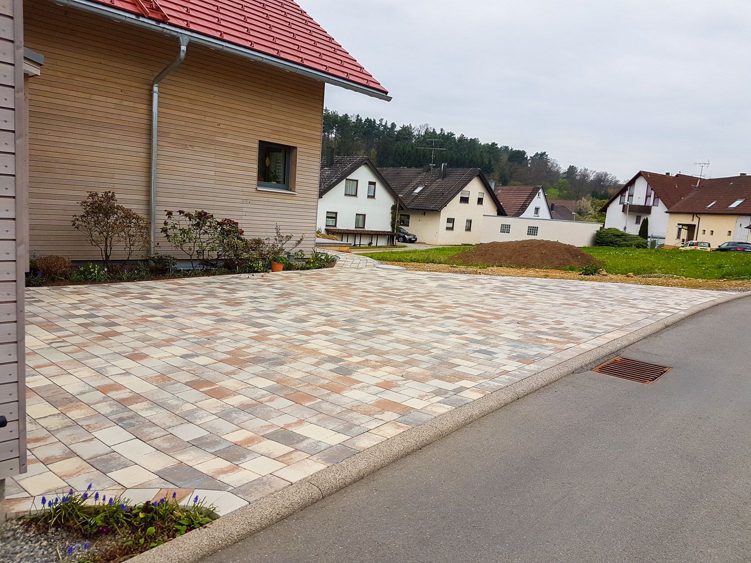 Eine Einfahrt vor einem Haus mit rotem Dach