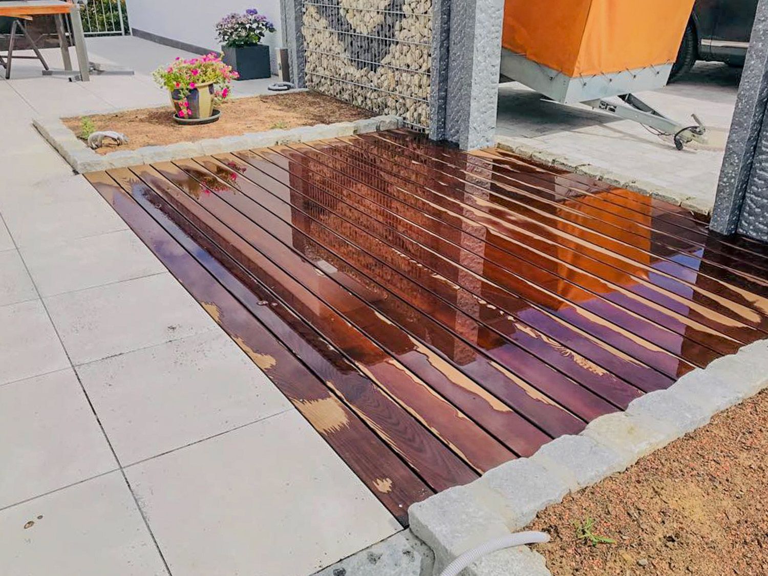 Ein Holzdeck mit einer Wasserpfütze darauf