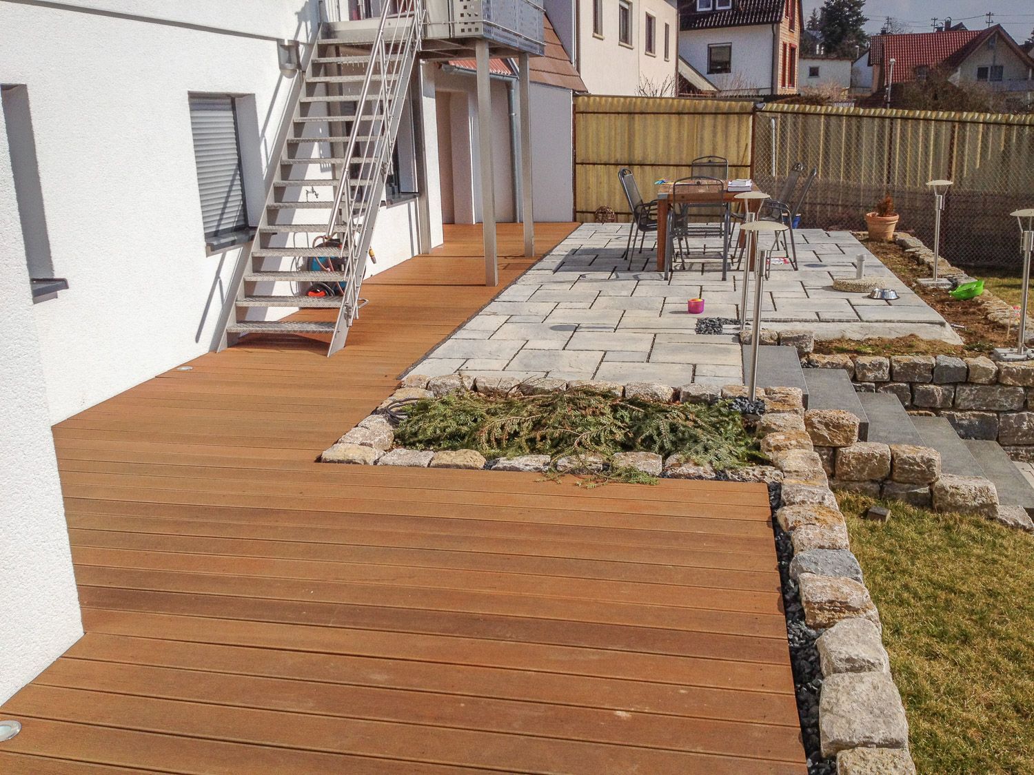 Eine Holzterrasse mit Tisch und Stühlen darauf