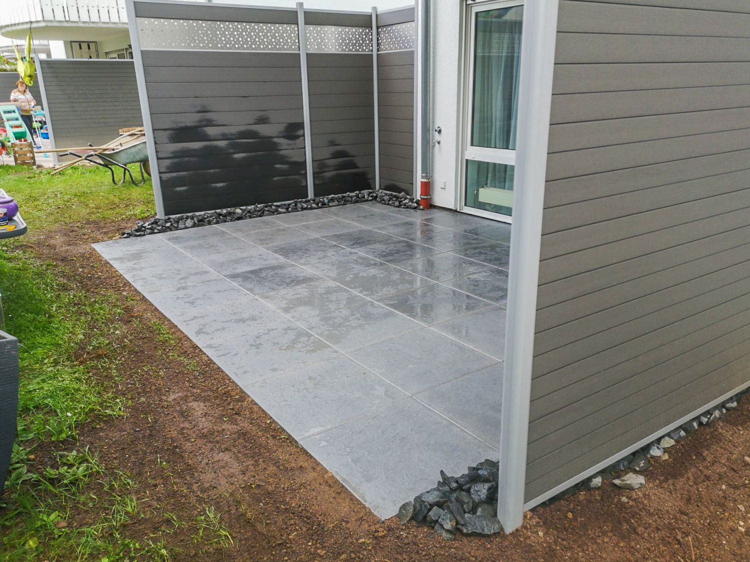 Im Hinterhof eines Hauses wird eine Terrasse gebaut.