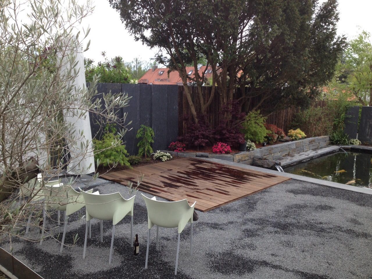 Eine Terrasse mit Tisch und Stühlen und einem Teich