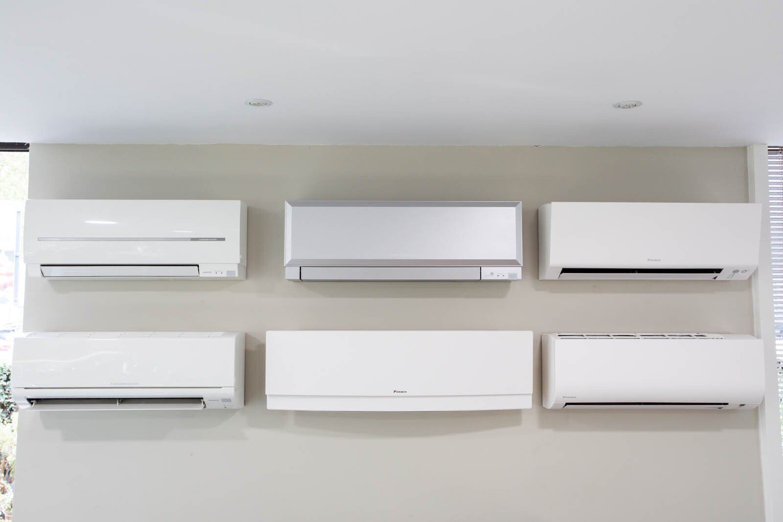 Six climatisations blanches exposées sur un mur
