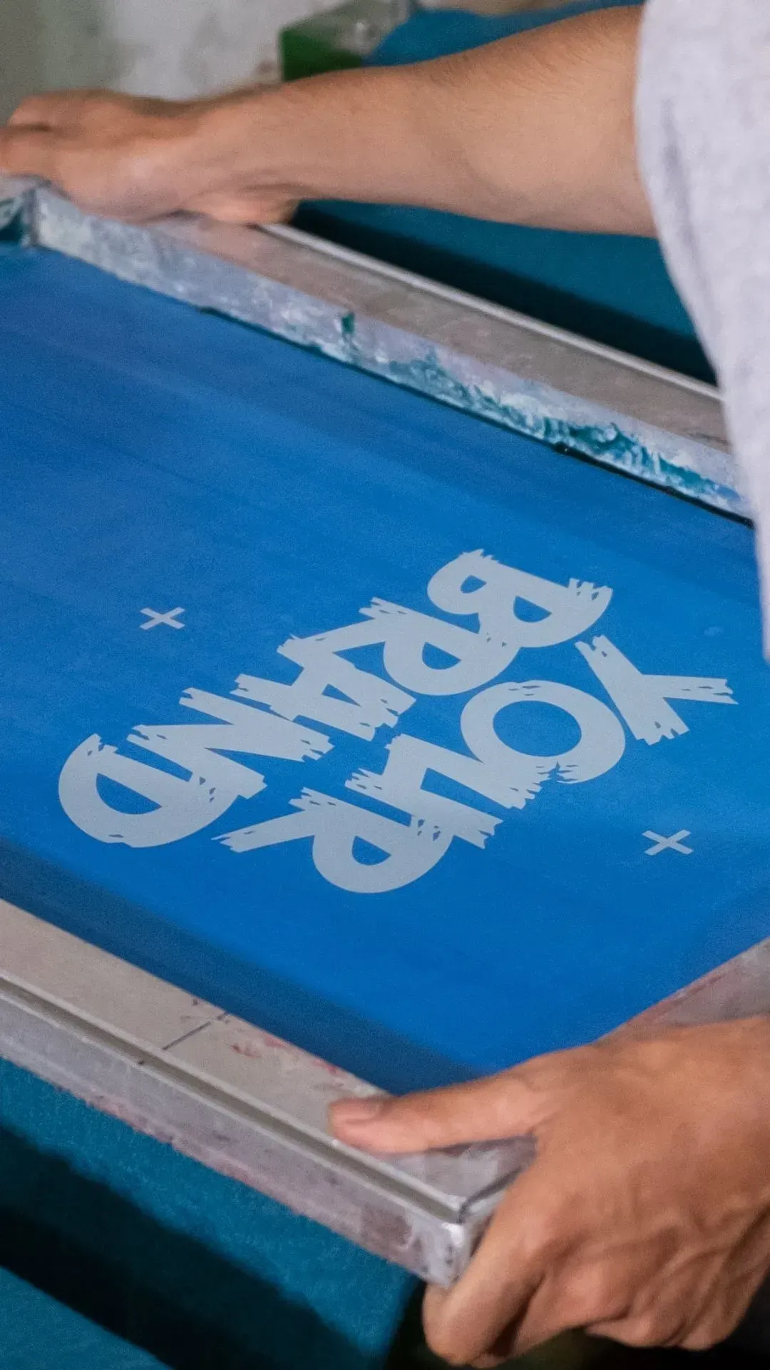 Una persona está imprimiendo un logotipo en una pantalla azul.