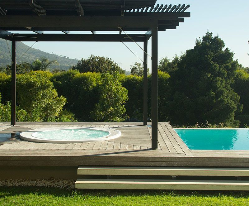 Ein Whirlpool steht auf einer Terrasse neben einem Swimmingpool