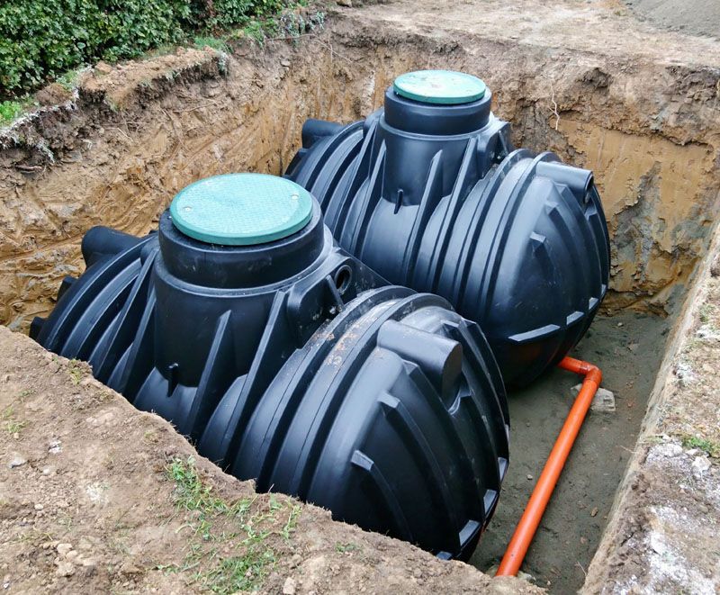 Ein paar schwarze Tanks stehen in einem Loch im Boden