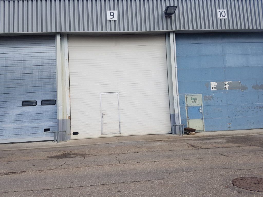 Façade bleu avec une porte de garage blanche