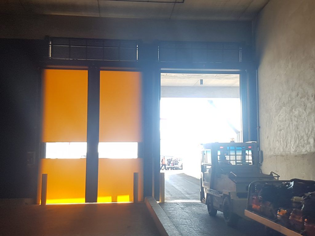 Une porte industrielle fermée et une autre ouverte