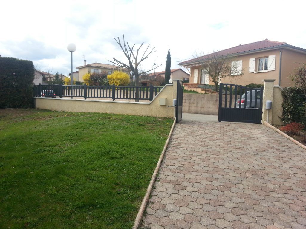 Pavage, gazon et portail ouvert battant