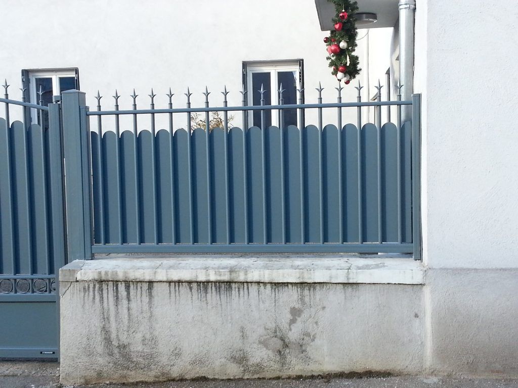 Un portail en alu gris avec une petite clôture