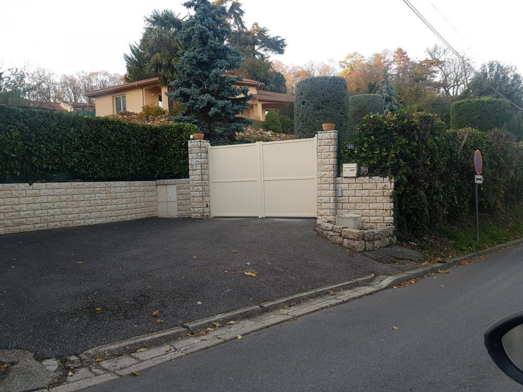 Un trottoir, muret avec clôture et portail blanc battant