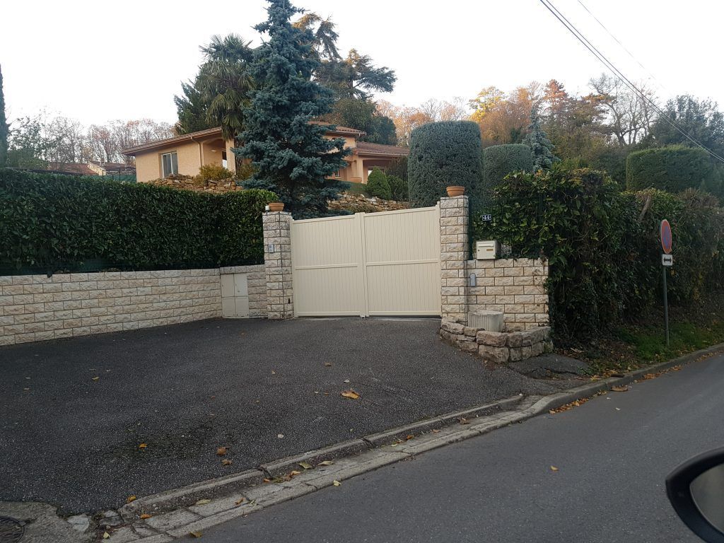 Entrée d'une maison avec muret en briques et portail blanc