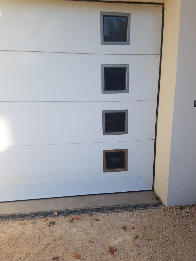 Porte de garage blanche avec carreaux