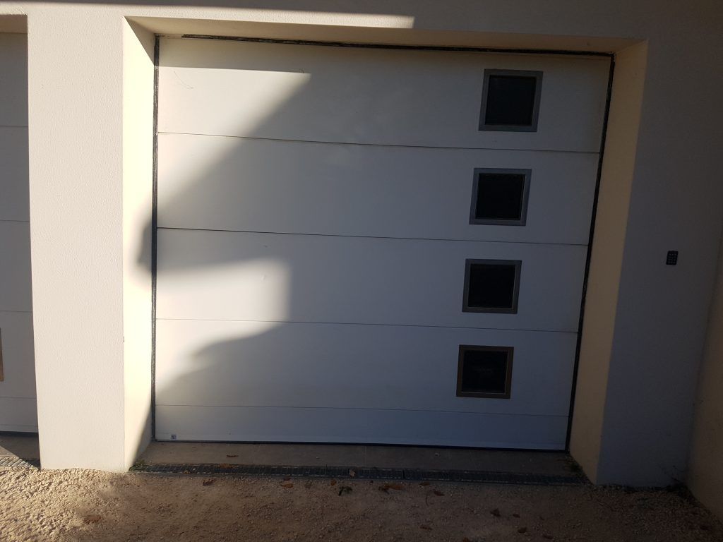 Une porte de garage sectionnelle avec des petites fenêtres