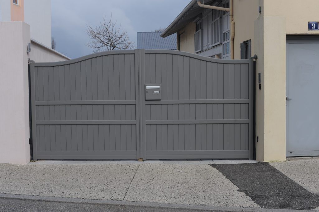 Un portail gris avec boîte aux lettres