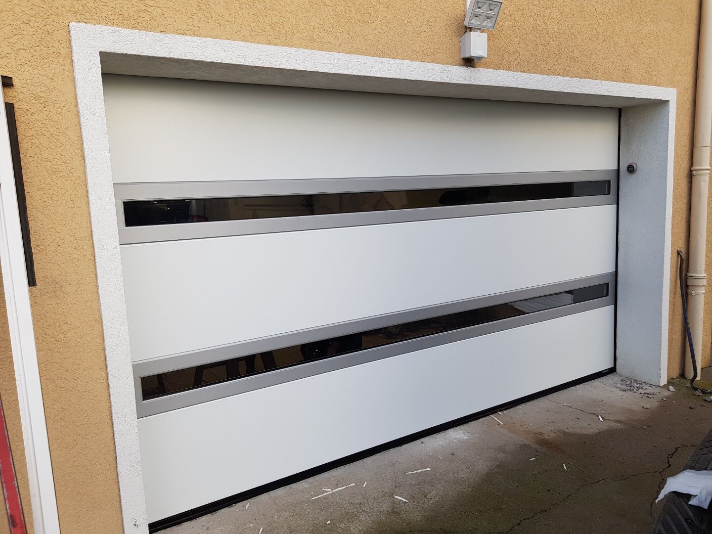 Une porte de garage blanche avec détails en verre