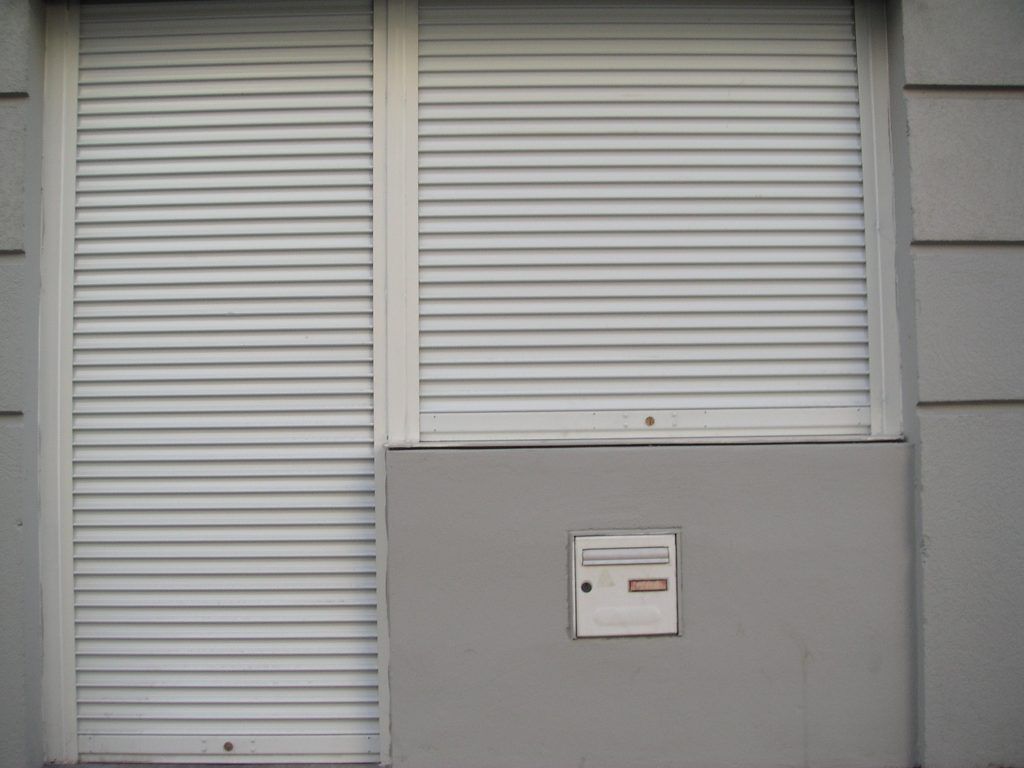 Porte-fenêtre et fenêtre avec les volets roulants fermés